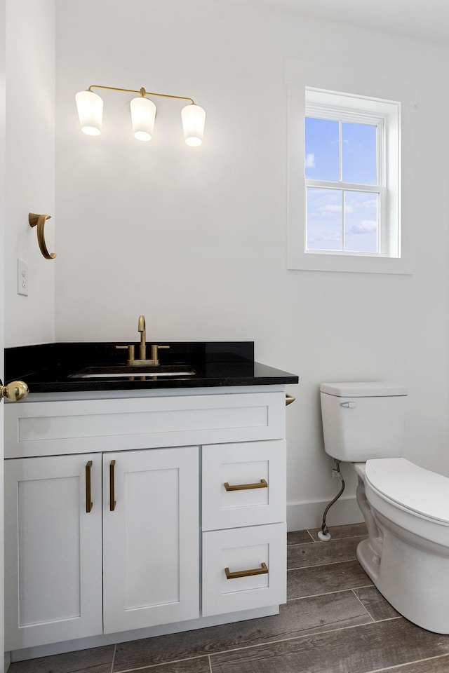 bathroom with hardwood / wood-style floors, vanity, and toilet