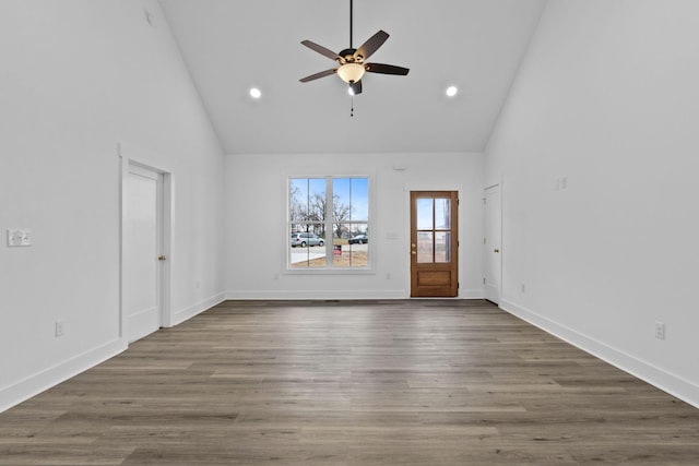 unfurnished living room with hardwood / wood-style floors, high vaulted ceiling, and ceiling fan