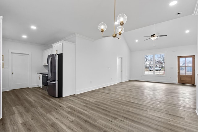 unfurnished living room featuring crown molding, high vaulted ceiling, ceiling fan with notable chandelier, and hardwood / wood-style flooring