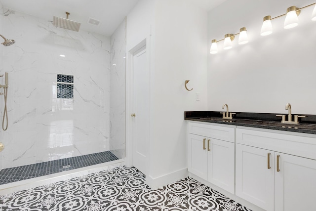 bathroom featuring tile patterned floors, vanity, and a tile shower