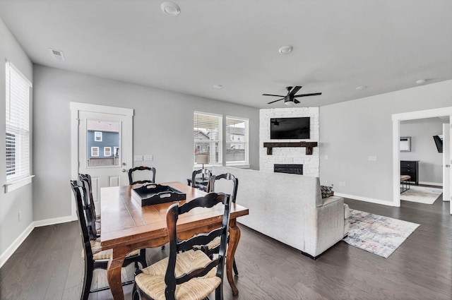 dining room with a fireplace, dark hardwood / wood-style floors, and ceiling fan