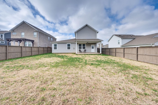 back of house featuring ceiling fan and a lawn