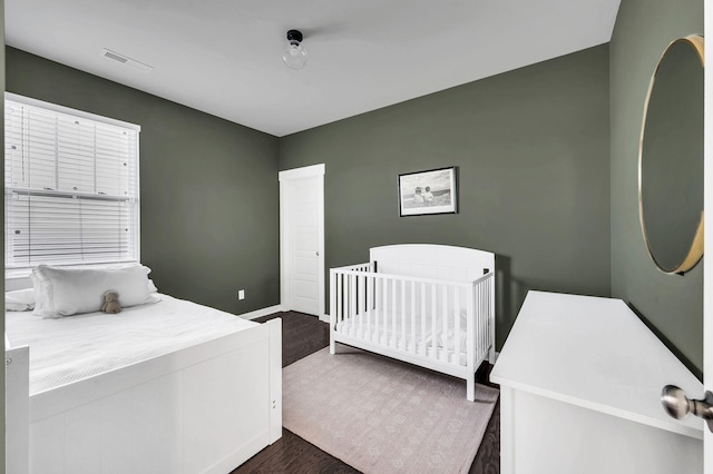 bedroom with dark hardwood / wood-style flooring