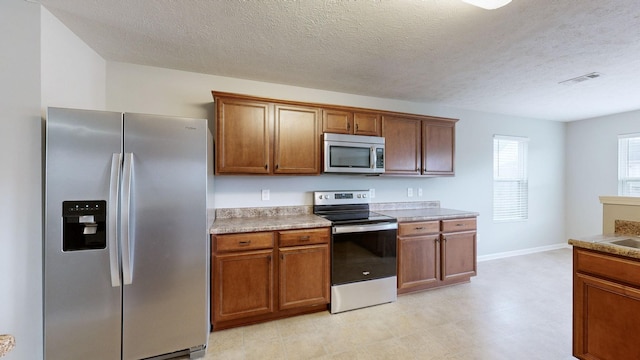 kitchen with a textured ceiling and stainless steel appliances