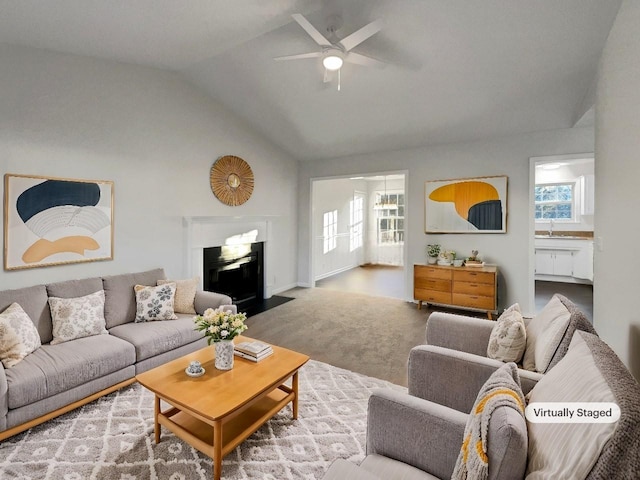 carpeted living room with ceiling fan and lofted ceiling