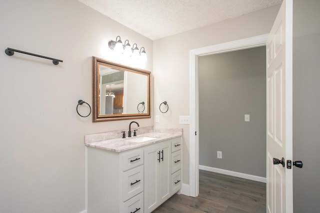 bathroom with hardwood / wood-style floors, vanity, and a textured ceiling