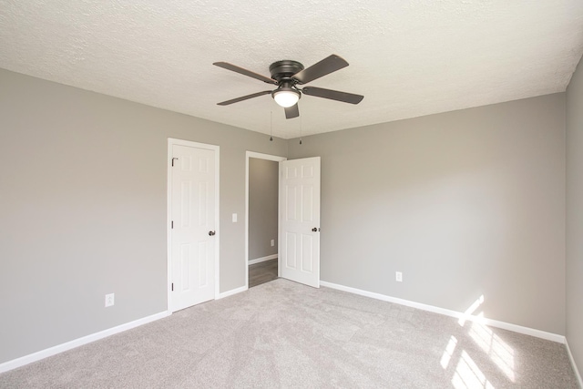 carpeted spare room featuring ceiling fan and a textured ceiling