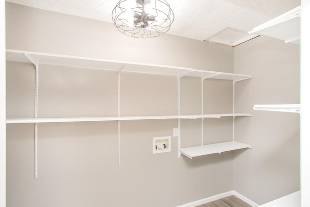 laundry room featuring hookup for a washing machine, wood-type flooring, and a textured ceiling