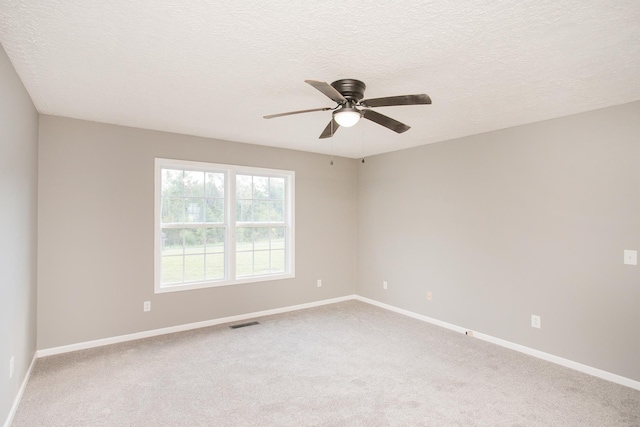 spare room featuring carpet, a textured ceiling, and ceiling fan