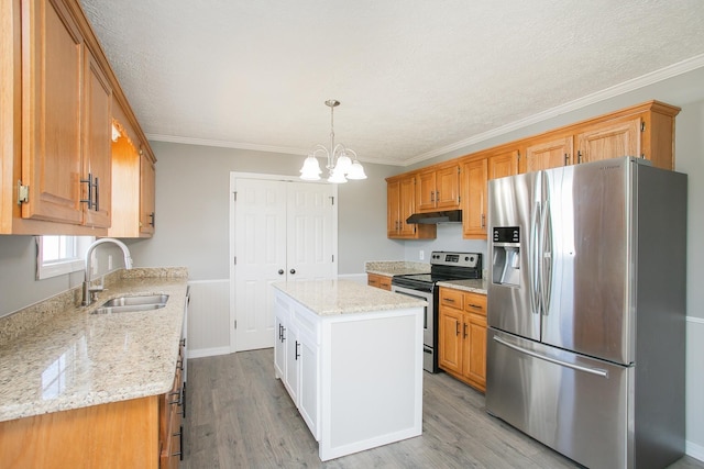 kitchen with sink, a center island, light wood-type flooring, appliances with stainless steel finishes, and ornamental molding