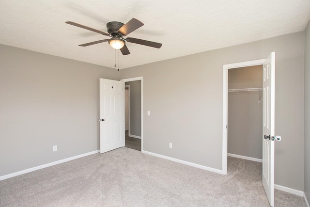 unfurnished bedroom with light carpet, a textured ceiling, a closet, and ceiling fan