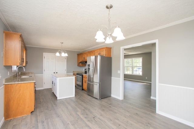 kitchen with appliances with stainless steel finishes, light wood-type flooring, sink, a notable chandelier, and a center island