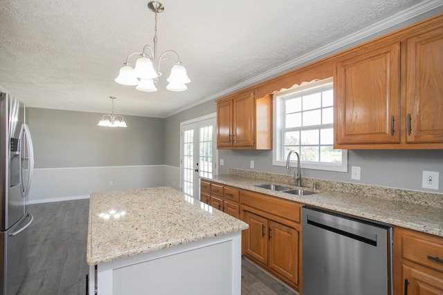 kitchen featuring sink, dark hardwood / wood-style floors, appliances with stainless steel finishes, decorative light fixtures, and a chandelier