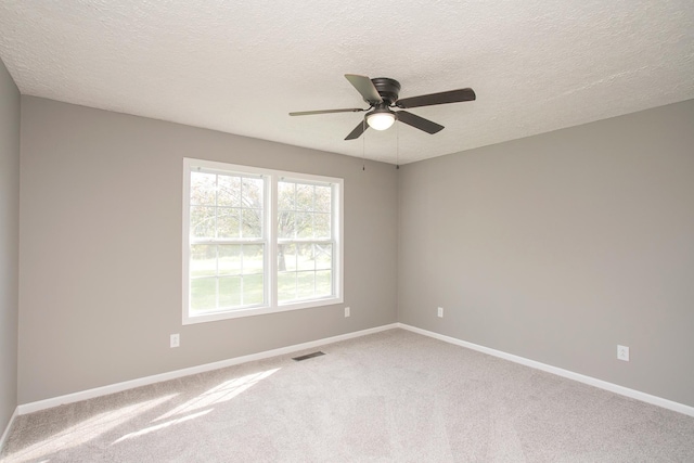 unfurnished room with carpet flooring, ceiling fan, and a textured ceiling