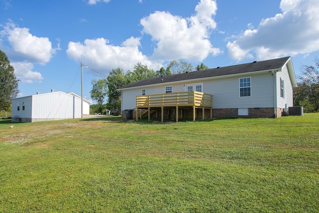 rear view of property with a lawn, cooling unit, and a deck