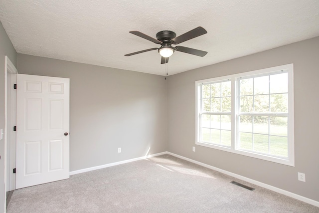 carpeted spare room with ceiling fan and a textured ceiling