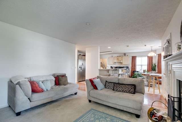 living room featuring light colored carpet and a textured ceiling