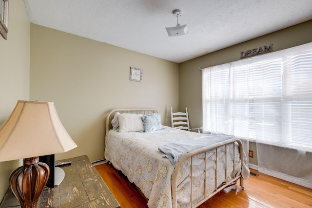 bedroom featuring wood-type flooring and a textured ceiling