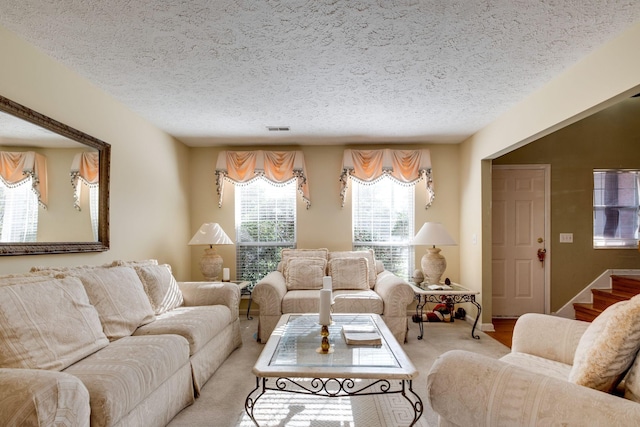 living room featuring light carpet and a textured ceiling