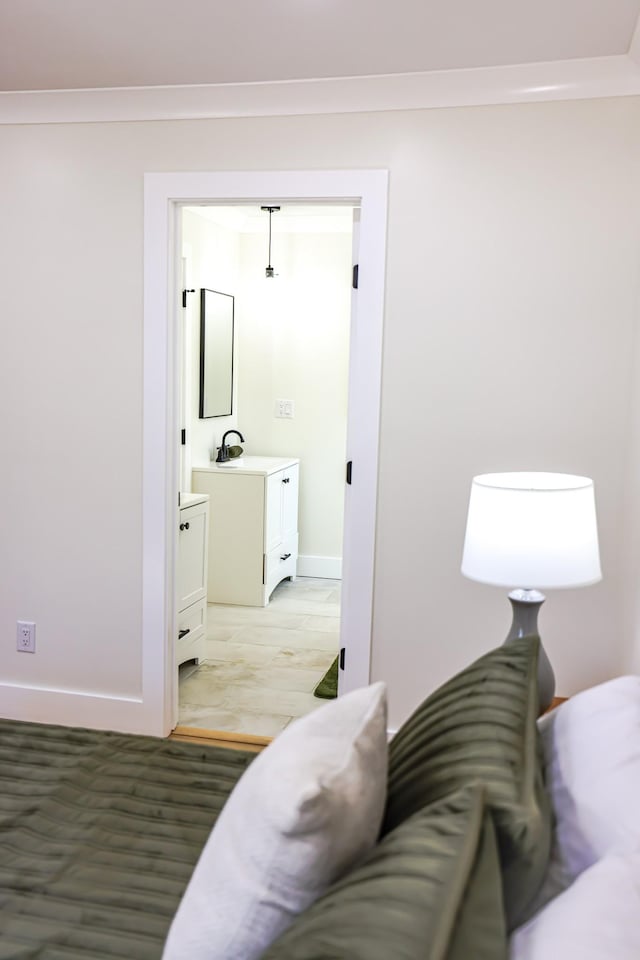 interior space featuring light hardwood / wood-style flooring, ensuite bath, crown molding, and sink