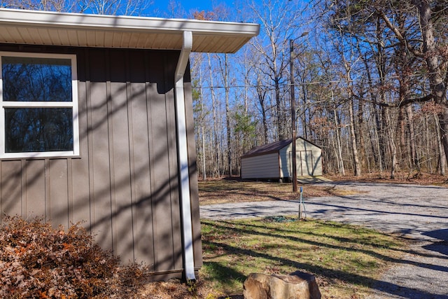 view of side of home featuring a storage shed