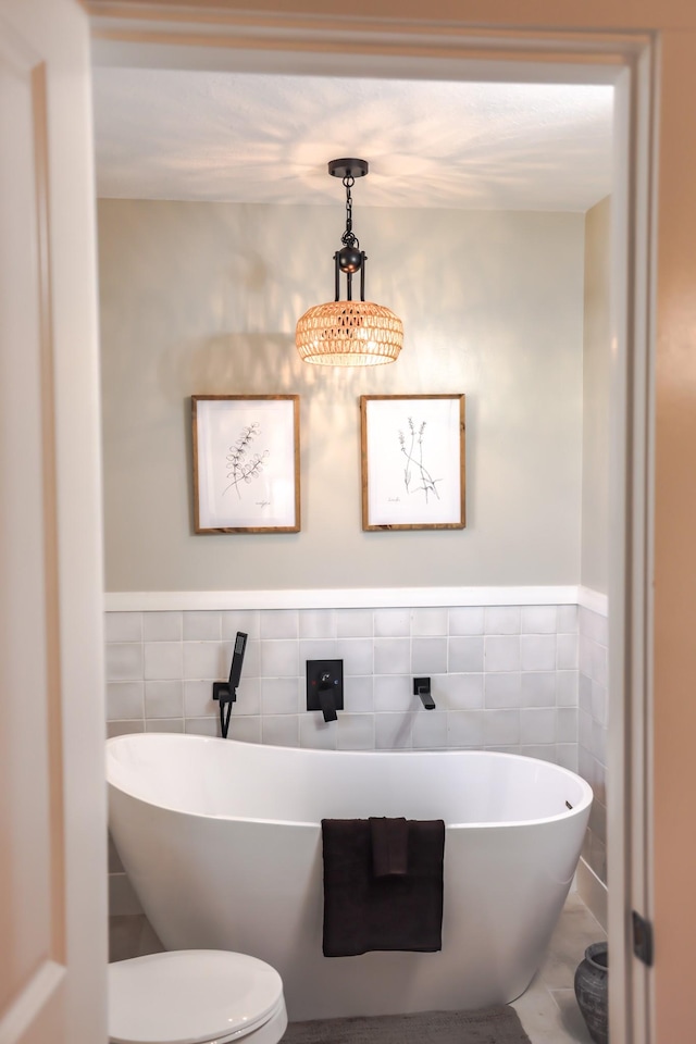 bathroom featuring toilet, tile walls, and a bathing tub