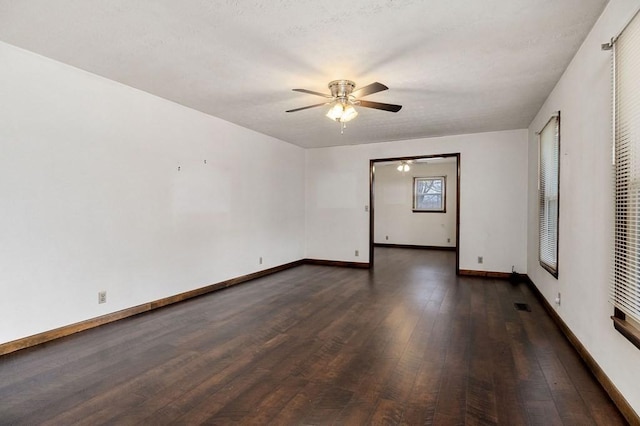 empty room with ceiling fan and dark wood-type flooring