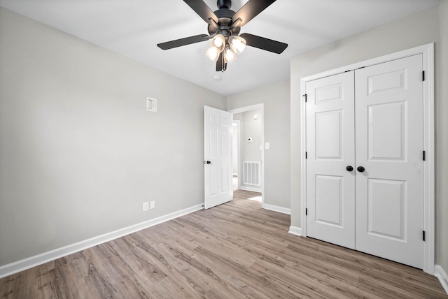 unfurnished bedroom with ceiling fan, a closet, and light wood-type flooring