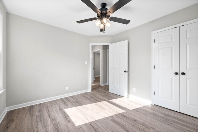 unfurnished bedroom with ceiling fan, light hardwood / wood-style flooring, and a closet