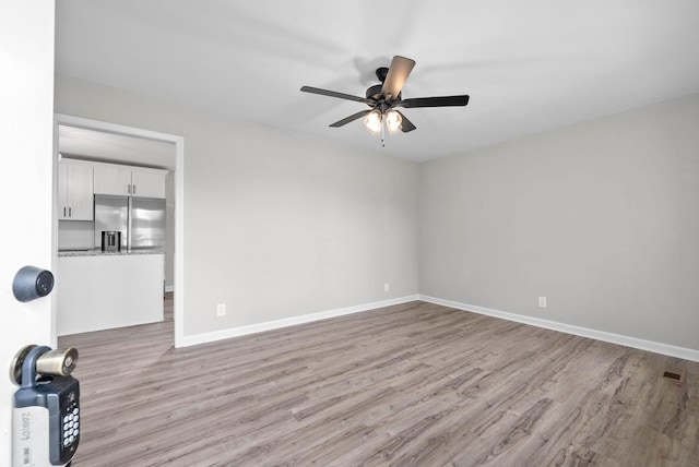 unfurnished room with ceiling fan and light wood-type flooring