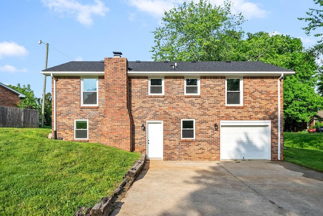 rear view of property featuring a garage and a yard