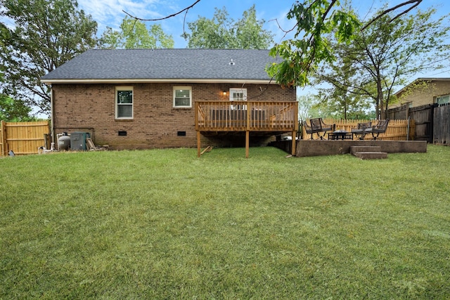 back of property with a deck and a lawn