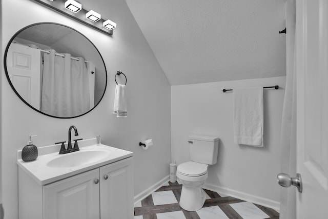 bathroom with toilet, vanity, and vaulted ceiling