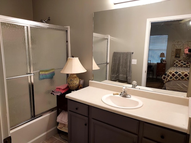 bathroom featuring tile patterned flooring, vanity, and enclosed tub / shower combo