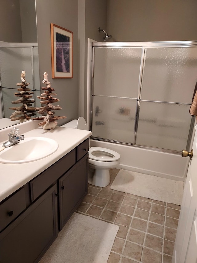 full bathroom featuring toilet, vanity, and combined bath / shower with glass door