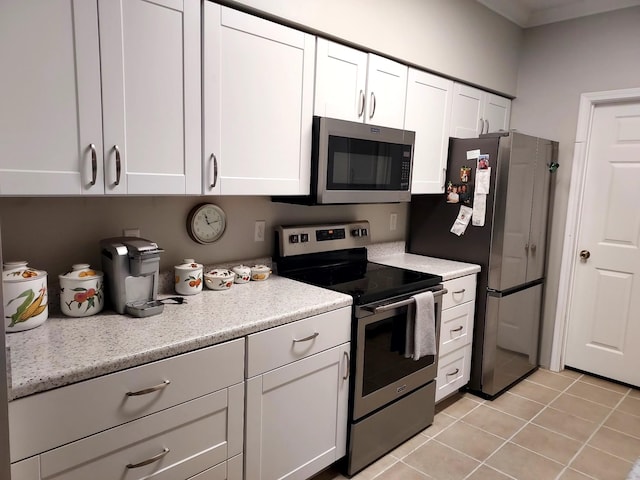 kitchen featuring white cabinets, light tile patterned flooring, and appliances with stainless steel finishes