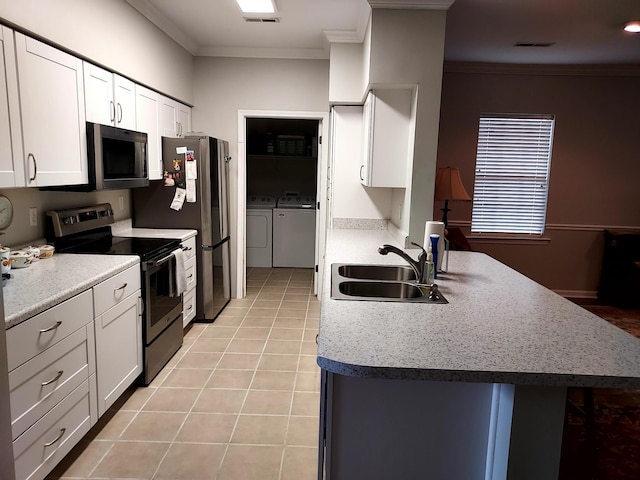 kitchen featuring appliances with stainless steel finishes, crown molding, sink, separate washer and dryer, and white cabinetry