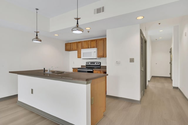 kitchen with electric range, sink, decorative light fixtures, and light hardwood / wood-style flooring