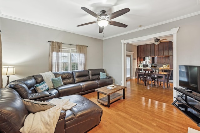 living room featuring light hardwood / wood-style flooring, ceiling fan, and ornamental molding