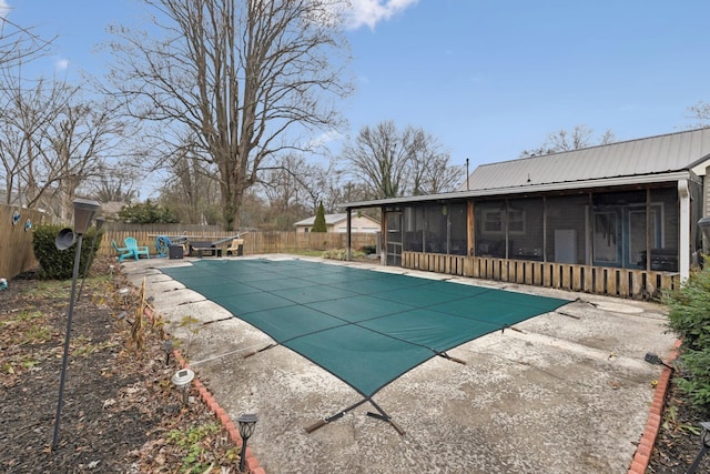 view of swimming pool featuring a patio area and a sunroom