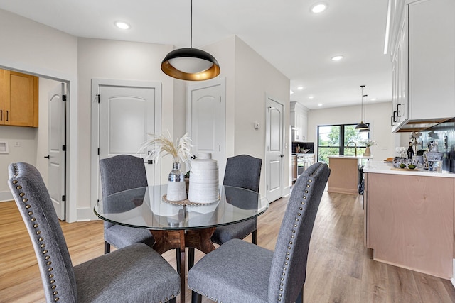 dining area with light hardwood / wood-style flooring and sink