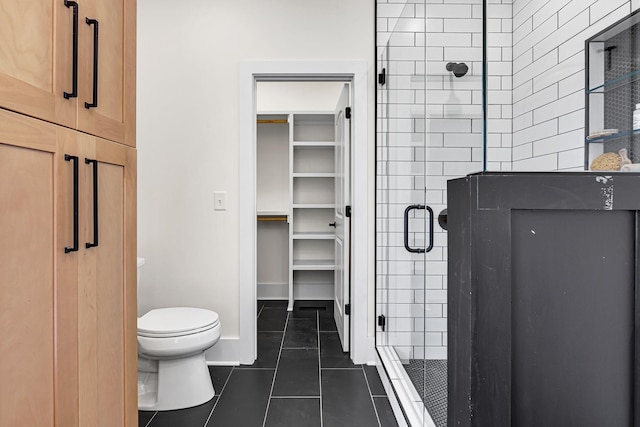 bathroom featuring tile patterned floors, toilet, and an enclosed shower