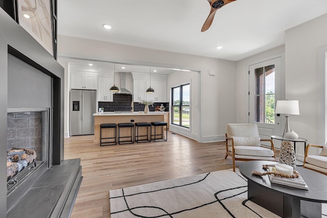 living room with light hardwood / wood-style flooring and ceiling fan