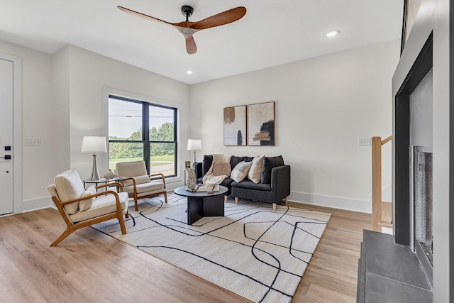 living room featuring ceiling fan and light hardwood / wood-style flooring