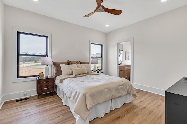 bedroom with ceiling fan, light wood-type flooring, and connected bathroom