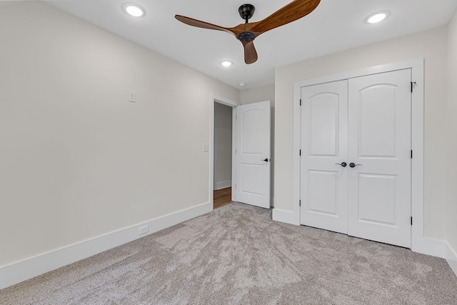 unfurnished bedroom with ceiling fan, light colored carpet, and a closet