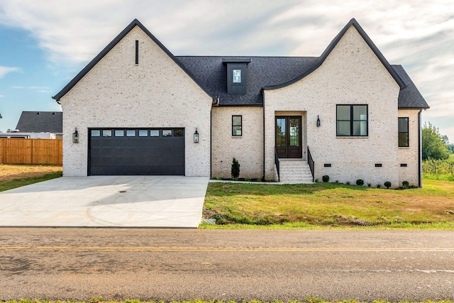 view of front facade featuring french doors, a front yard, and a garage