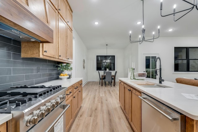 kitchen with appliances with stainless steel finishes, backsplash, premium range hood, sink, and pendant lighting