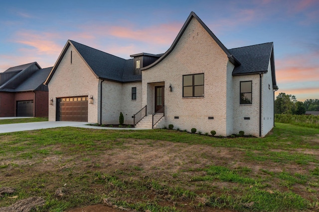 view of front of house featuring a garage and a lawn