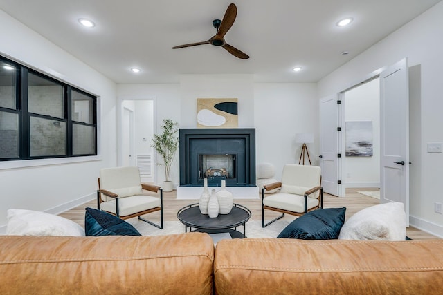 living room with light hardwood / wood-style floors and ceiling fan